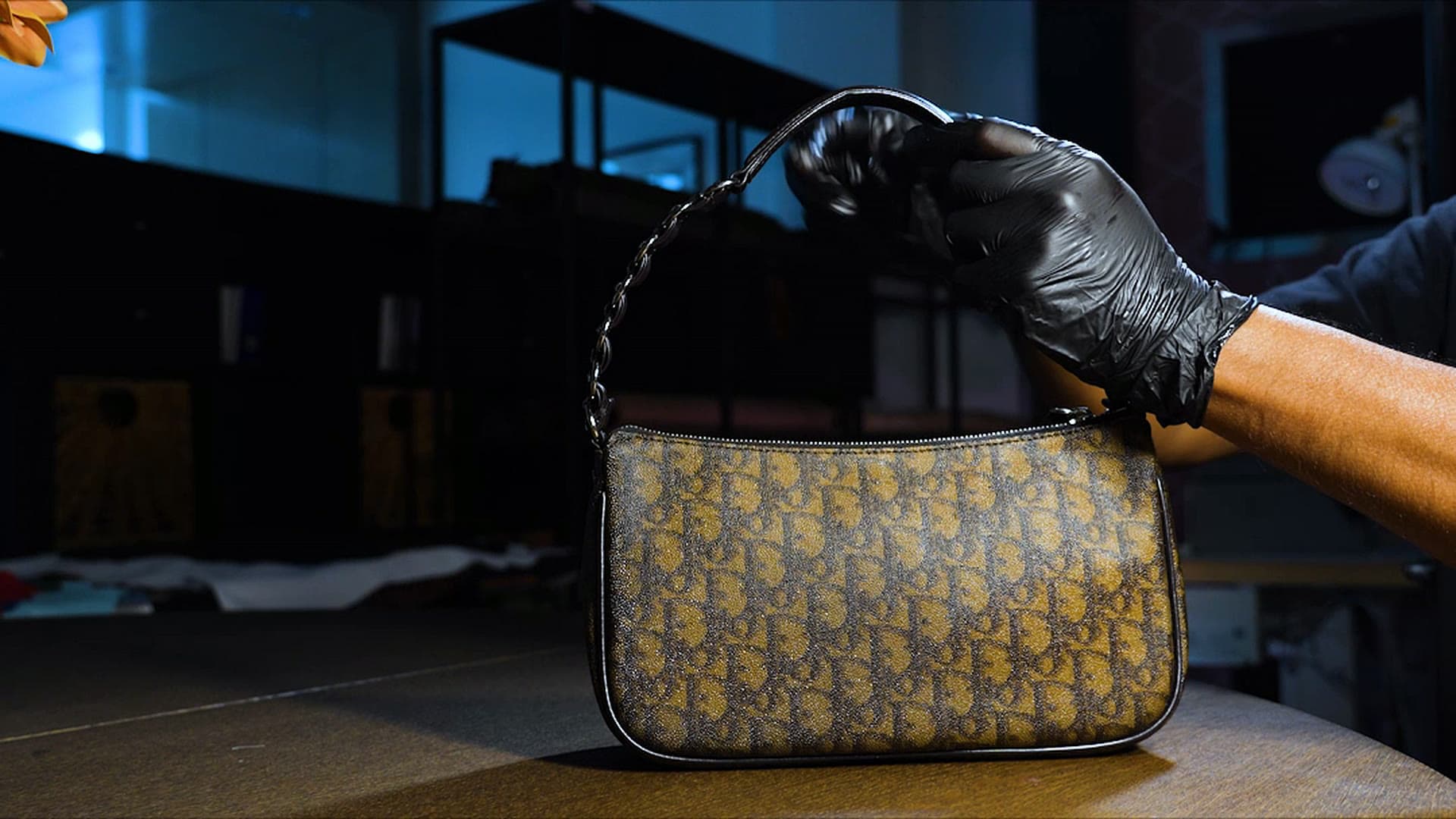 A monogram canvas shoulder bag, restored, lifted from the workshop bench